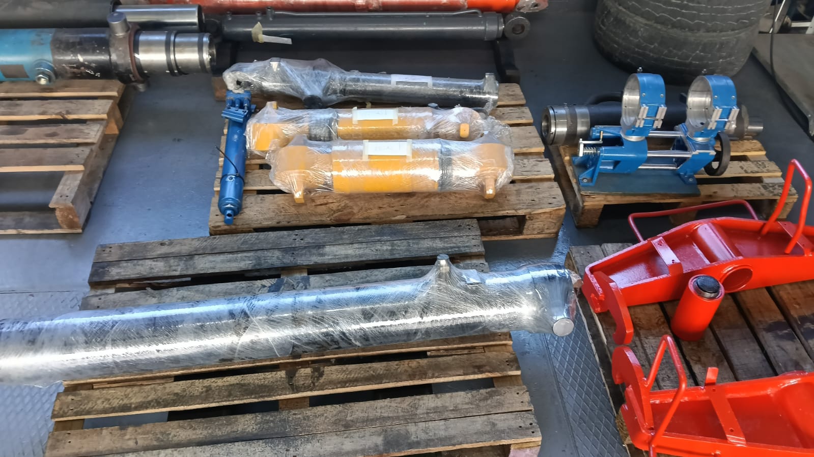Reconditioned hydraulic cylinders painted and wrapped on pallets